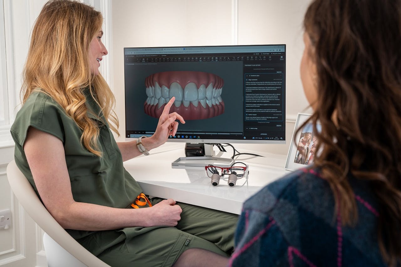 Dentist showing a digital teeth model on the screen to the patient