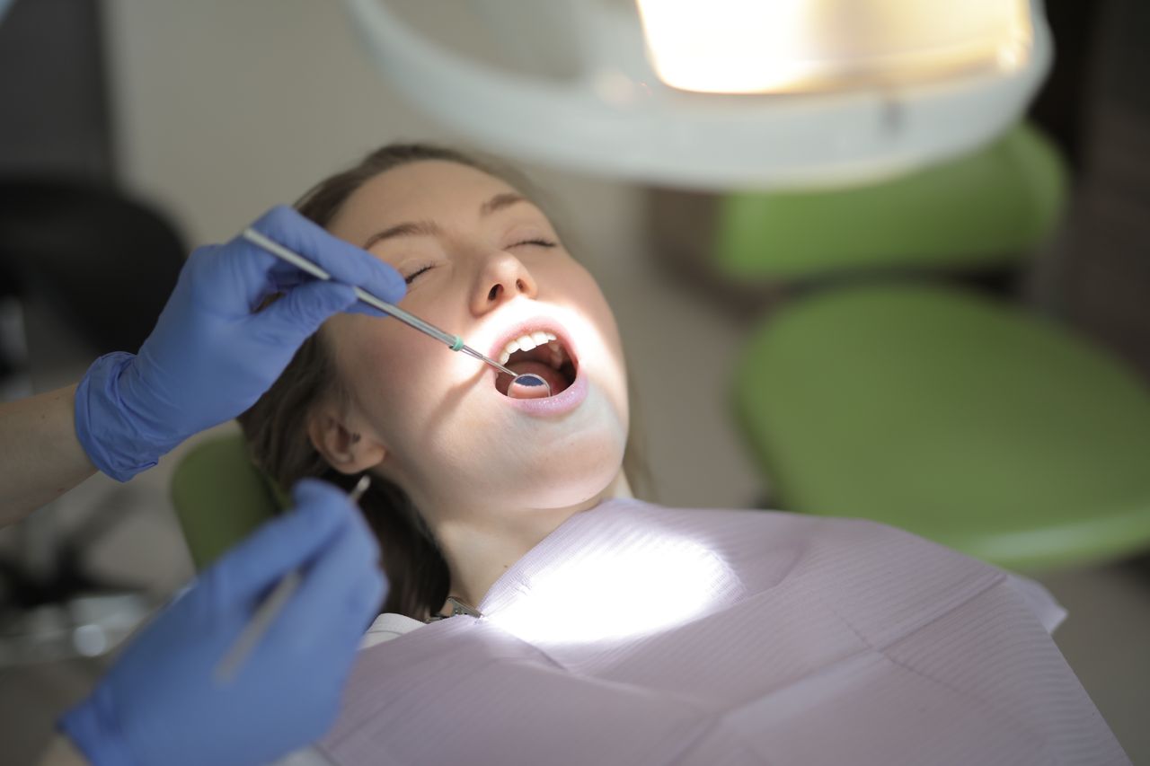 Dentist examining persistent mouth sore during oral assessment
