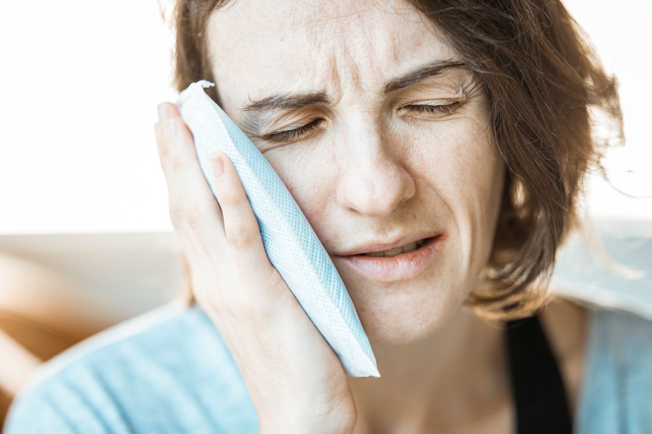 Person using a cold compress for immediate dental trauma first aid